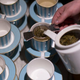 Person pouring tea into traditional British tea service